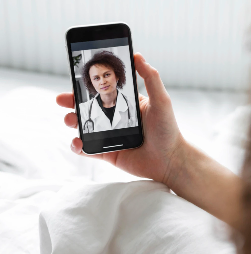 Un médico atiende una videoconsulta desde un teléfono móvil